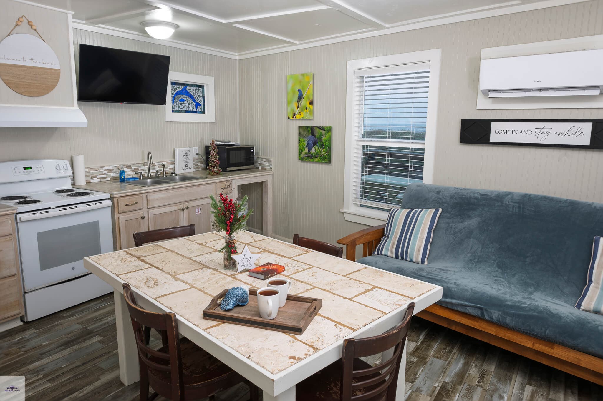 A cozy kitchen and living area featuring a dining table, sofa, and modern appliances.